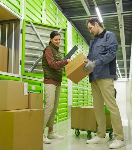 Deux personnes rangent des cartons dans un box